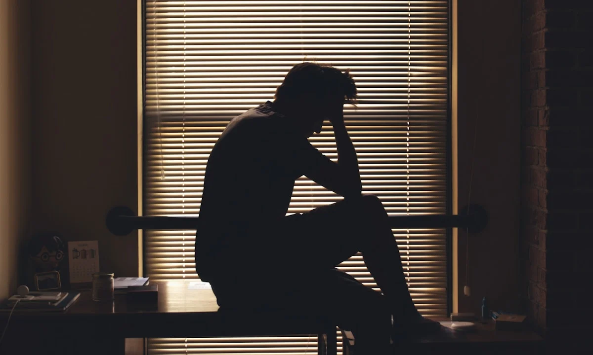 A silhouetted person appears worried and alone