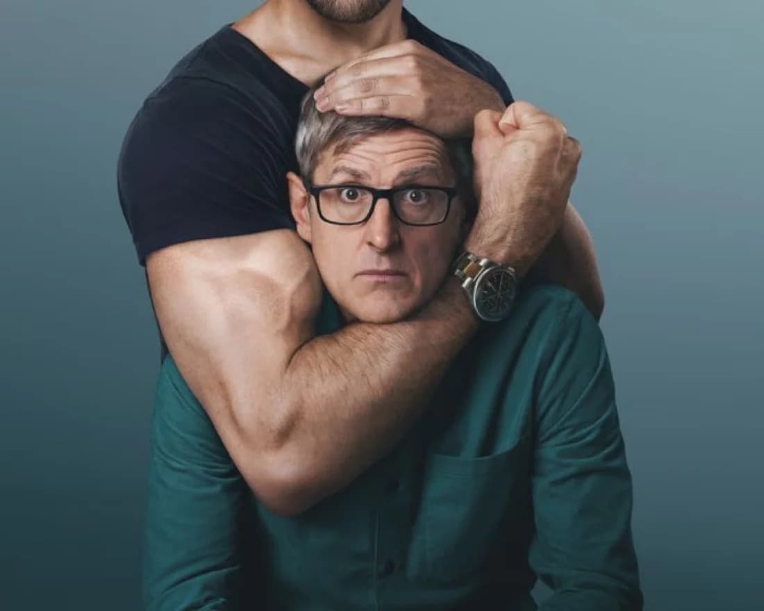 Louis Theroux looking alarmed while held in a man's arm in Inside the Manosphere