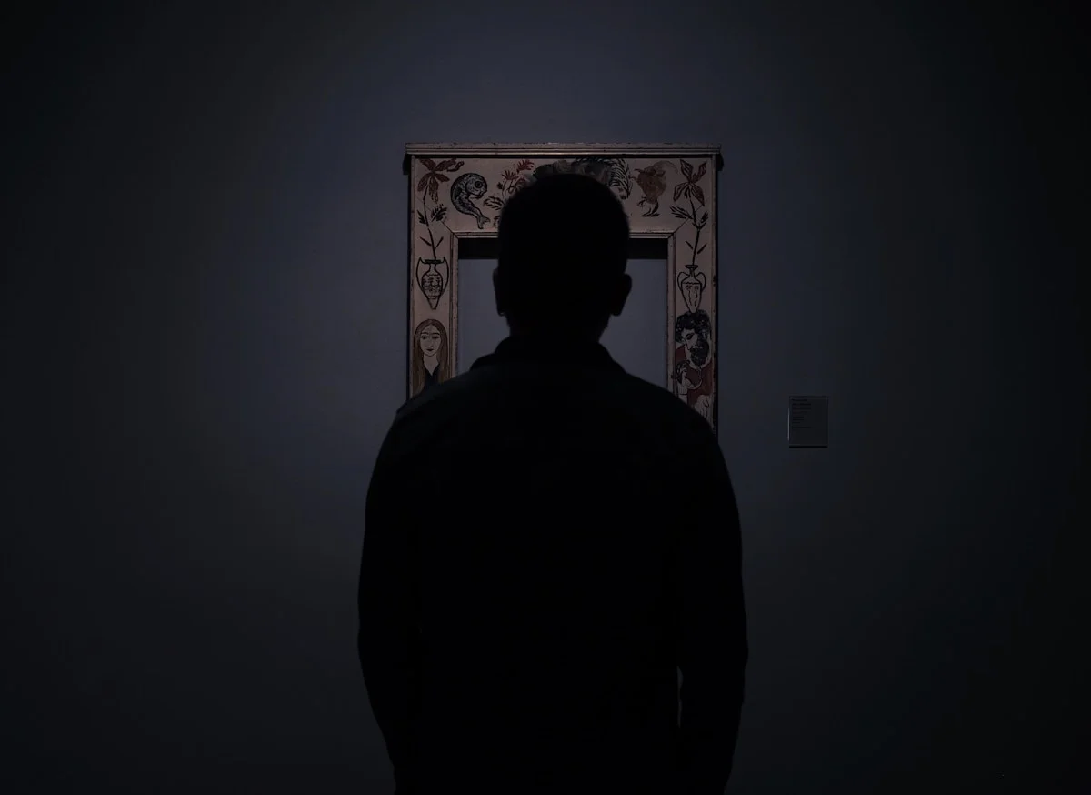 Silhouette of person facing an empty photo frame