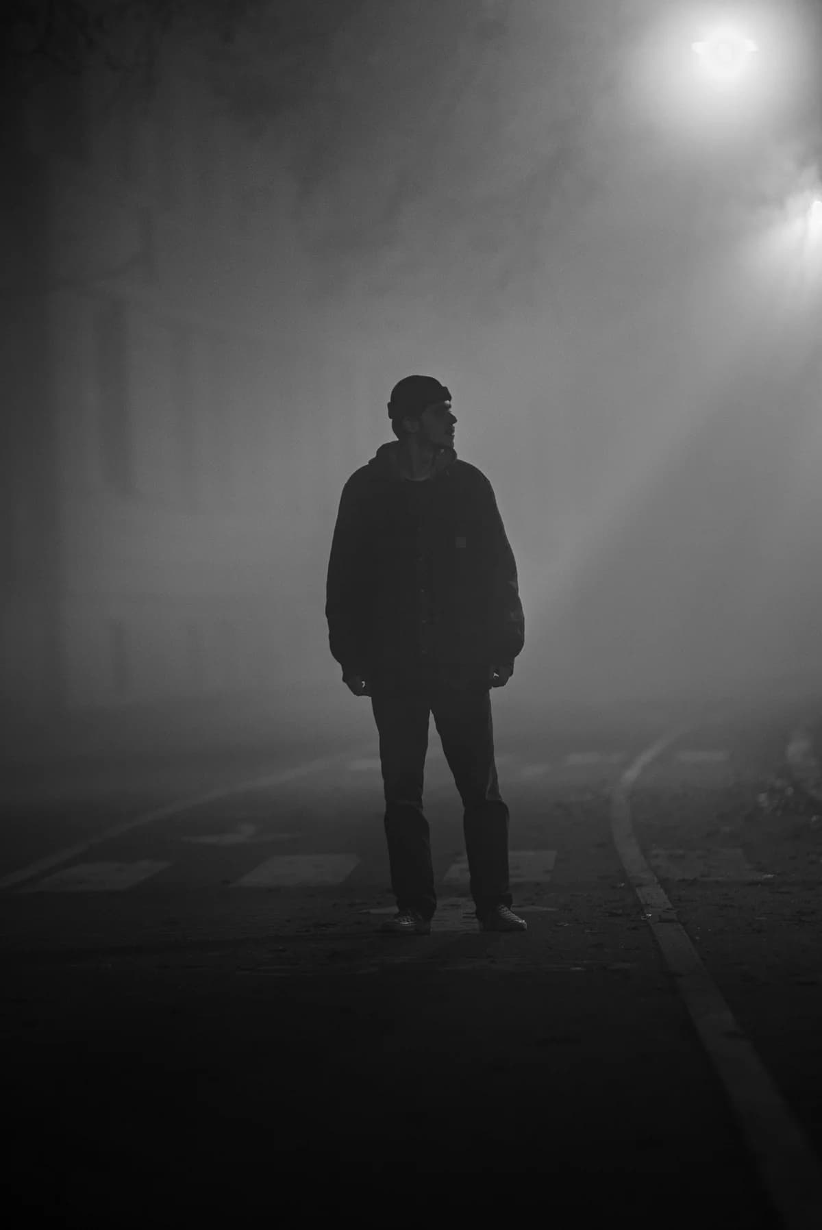 A man standing in the middle of a foggy street